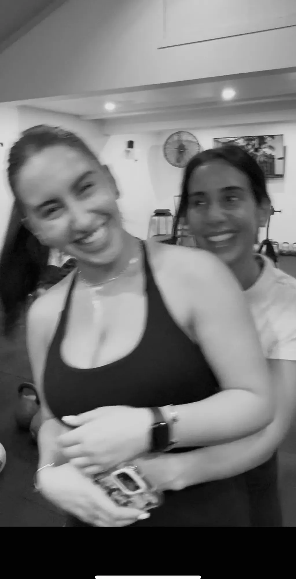 Two LNPT members smile together in the studio after training.