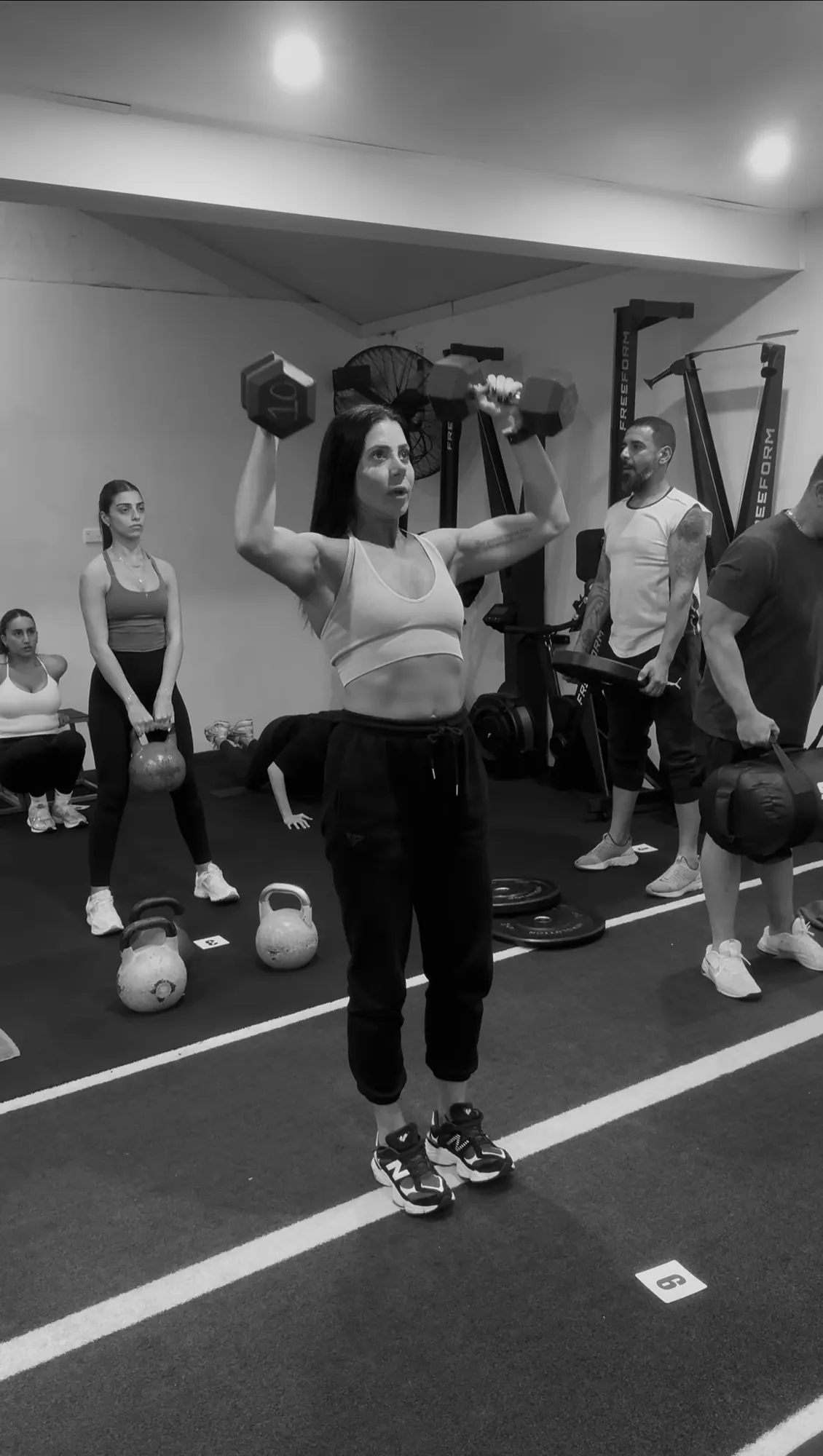 LNPT members perform a dumbbell strength exercise during a class.